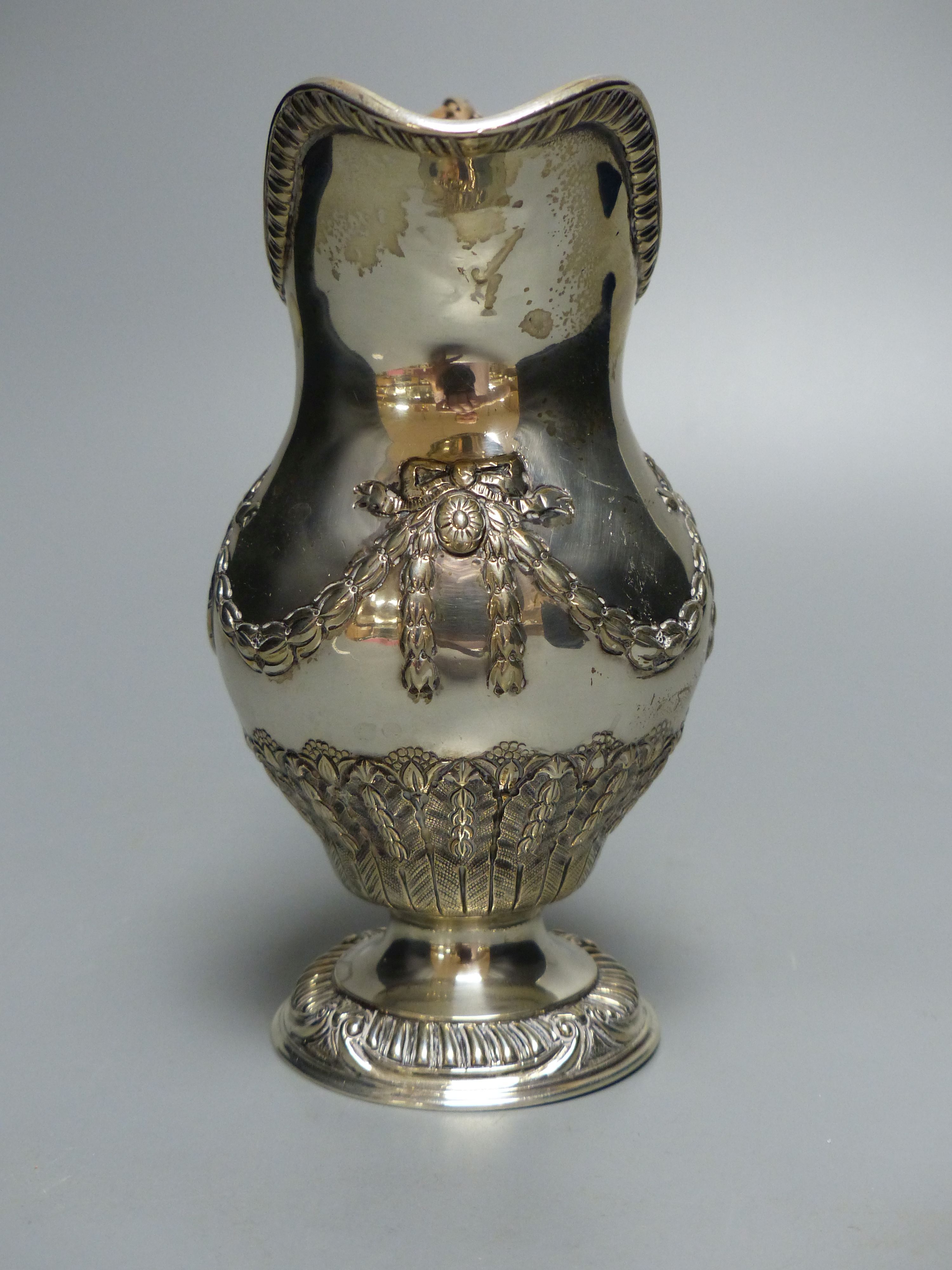 An Edwardian silver cream jug, with rattan handle, Goldsmiths & Silversmiths Co Ltd, London, 1909, 15.5cm, 8oz.